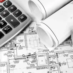 Kalkulator i zwoje planów architektonicznych. Na planach widać oznaczenia, które wskazują, co wchodzi w punkt elektryczny, np. 1x250 101 TA1 1P.