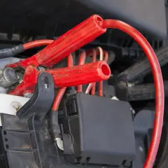 Czerwone klemy podłączone do akumulatora. Zobacz, jak podłączyć klemy, aby uruchomić auto.