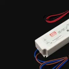 Zasilacz LED z oznaczeniami napięcia i mocy. Urządzenie ma białą obudowę i kable w kolorach czerwonym, czarnym, brązowym i niebieskim.