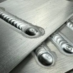 Precyzyjne ostrzenie elektrody TIG aluminium, widoczne na kilku spawach o charakterystycznym, falistym wzorze.