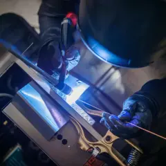 Spawanie TIG podstawy: precyzyjne połączenie metalu przez doświadczonego spawacza w ochronnym stroju.