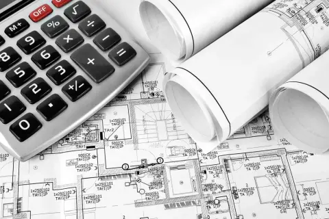 Kalkulator i zwoje planów architektonicznych. Na planach widać oznaczenia, które wskazują, co wchodzi w punkt elektryczny, np. 1x250 101 TA1 1P.