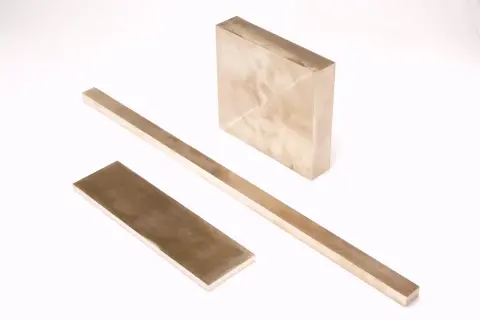 Trzy metalowe sztabki, jedna kwadratowa i dwie prostokątne, leżą na białym tle. Czy wiesz, w jakiej temperaturze topi się aluminium?