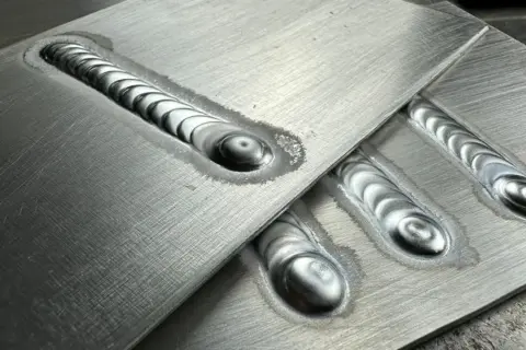 Precyzyjne ostrzenie elektrody TIG aluminium, widoczne na kilku spawach o charakterystycznym, falistym wzorze.