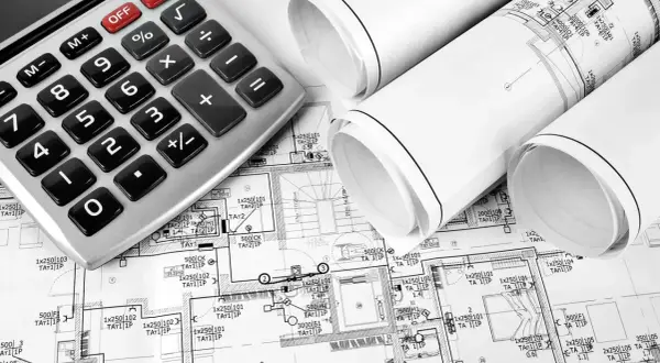 Kalkulator i zwoje planów architektonicznych. Na planach widać oznaczenia, które wskazują, co wchodzi w punkt elektryczny, np. 1x250 101 TA1 1P.