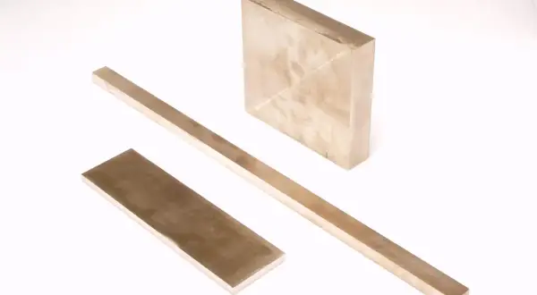Trzy metalowe sztabki, jedna kwadratowa i dwie prostokątne, leżą na białym tle. Czy wiesz, w jakiej temperaturze topi się aluminium?