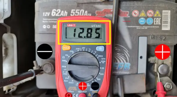 Multimetr pokazuje 12.85V, co jest wynikiem pomiaru napięcia akumulatora. Tak obliczyć napięcie.