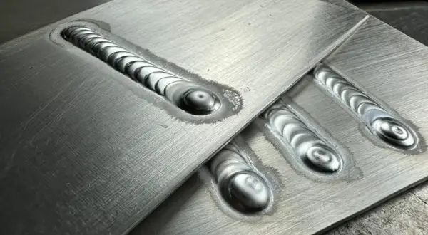 Precyzyjne ostrzenie elektrody TIG aluminium, widoczne na kilku spawach o charakterystycznym, falistym wzorze.