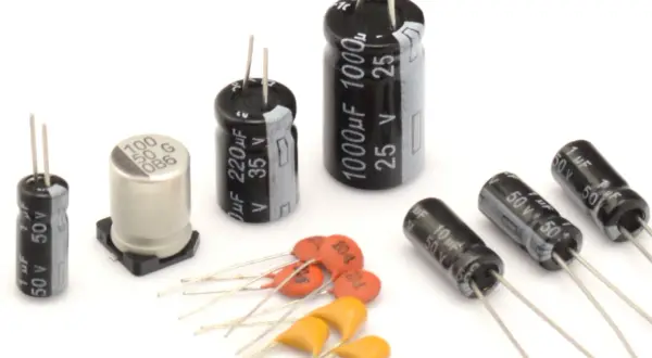 Różne rodzaje kondensatorów: elektrolityczne, ceramiczne i tantalowe. Widać ich oznaczenia pojemności i napięcia.