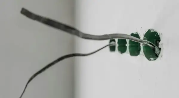 Przewody elektryczne wychodzące z zielonych puszek instalacyjnych, gotowe do podłączenia. Prąd w obu przewodach zapewni zasilanie.