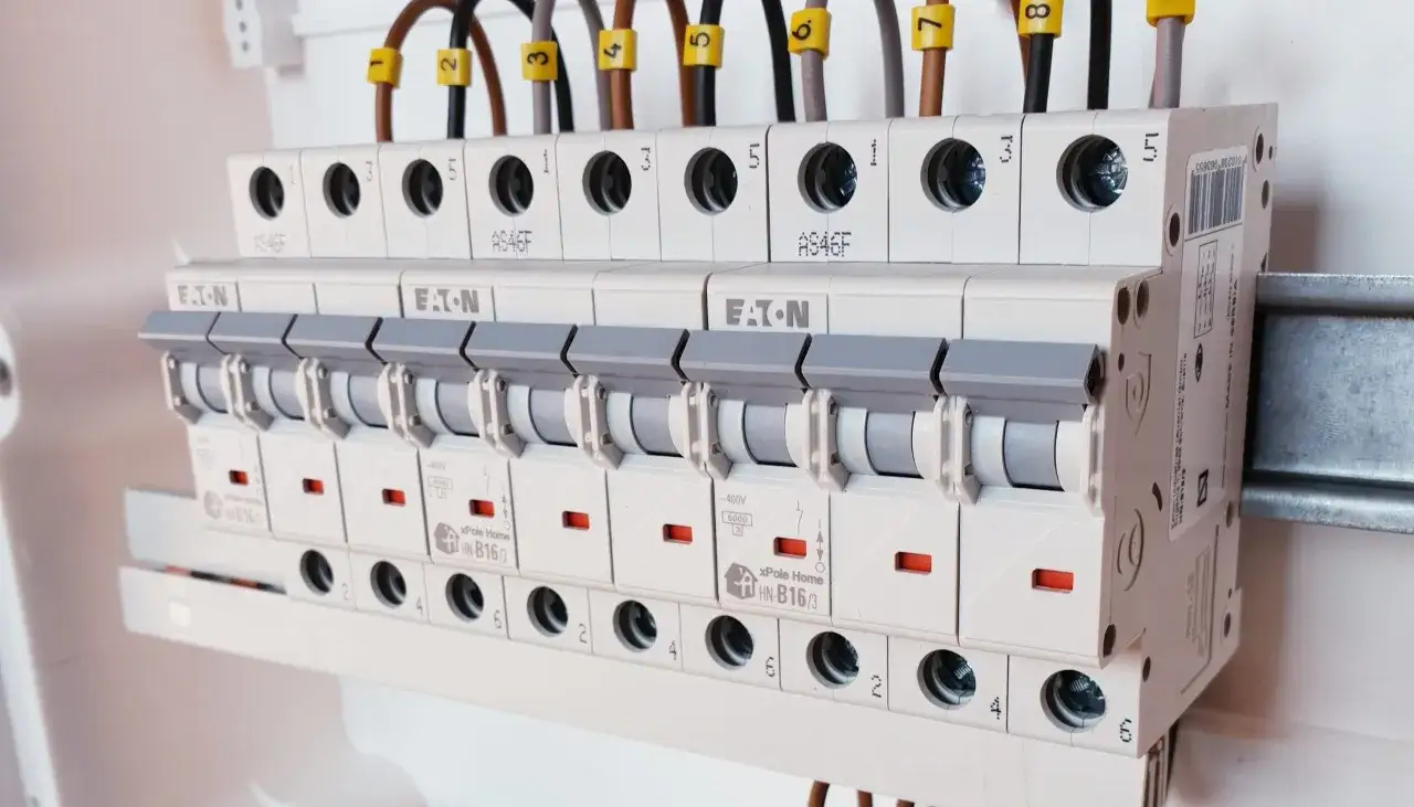 Szukasz informacji, jak dobrać wyłącznik nadprądowy? Na zdjęciu widać fragment rozdzielnicy elektrycznej z kilkoma rzędami wyłączników.