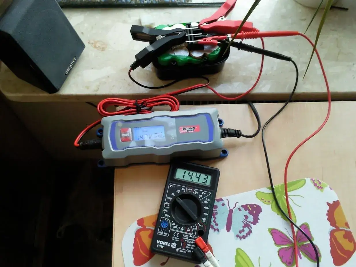 Ładowarka Ultimate Speed pokazuje 14.3V, a multimetr 14.43V. To wskaz&oacute;wka, jak długo ładować akumulator do wkrętarki 12v.