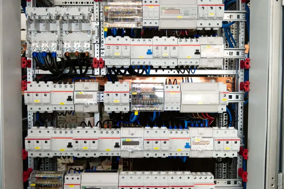 Panel z licznymi wyłącznikami i przewodami, gotowy do instalacji elektrycznej samemu.