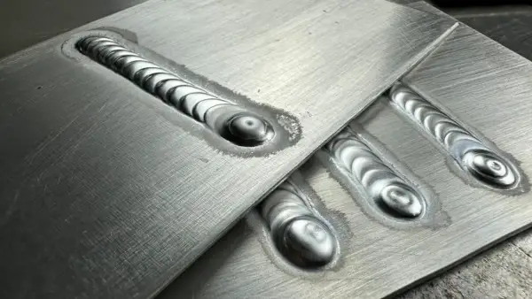 Precyzyjne ostrzenie elektrody TIG aluminium, widoczne na kilku spawach o charakterystycznym, falistym wzorze.